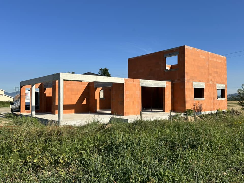 Maison individuelle en construction avec des murs en briques rouges. Obtention permis de construire.